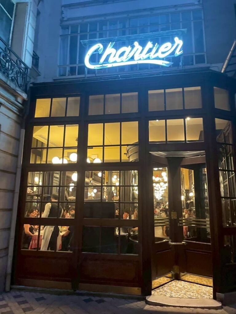 夜のパリに輝く「Chartier」の青いネオンとクラシックな外観