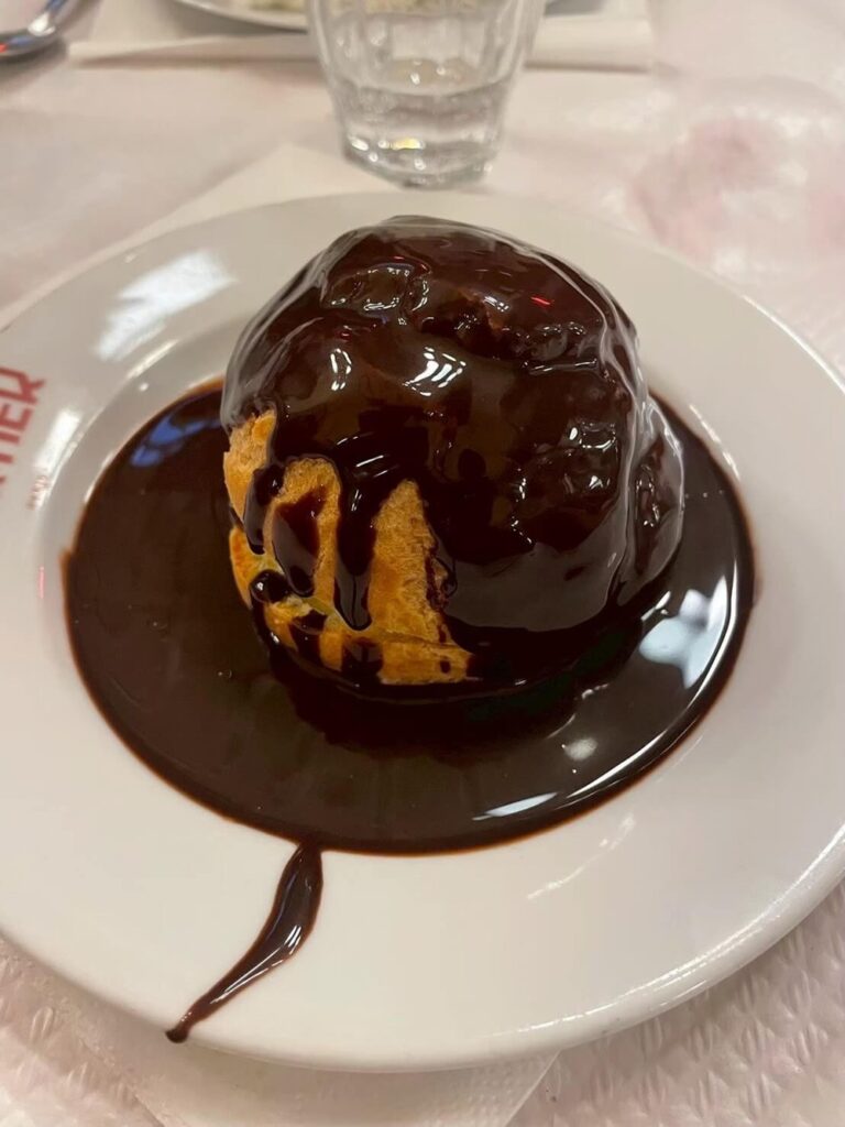 たっぷりの濃厚チョコレートソースがかけられたプロフィトロール