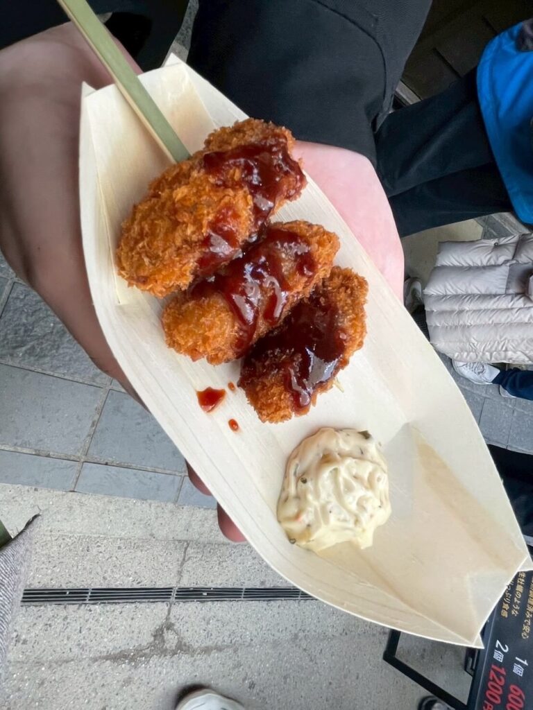揚げたてのカキフライ串。タルタルソースがついていて食べ歩きに最適