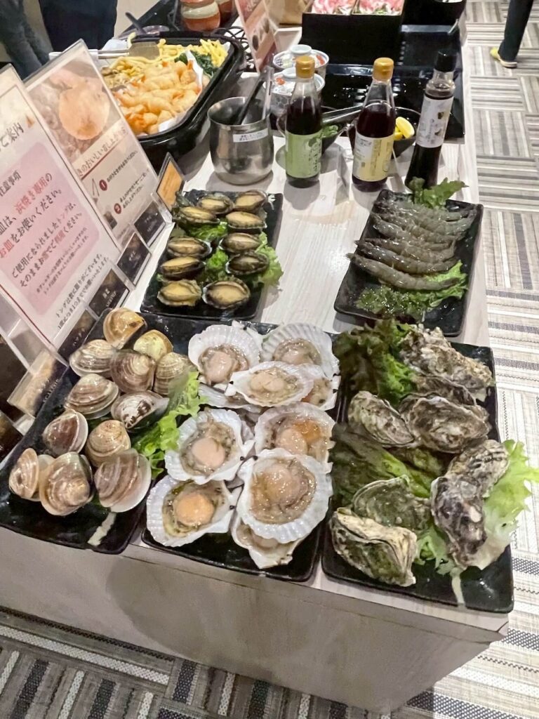夕食ビュッフェに並ぶ牡蠣、サザエ、エビ、アワビなどの豪華海鮮