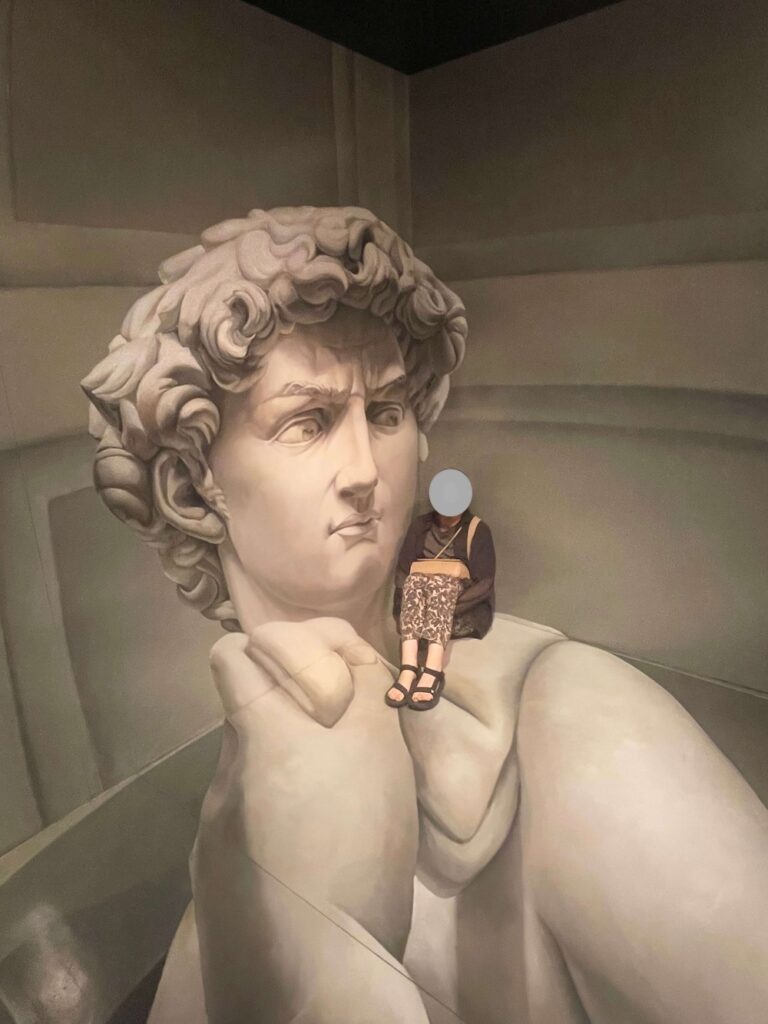 トリックアートピアのミケランジェロ館で大きな彫刻に乗っているように見えるトリックアート