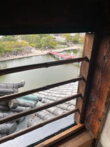 松本城の格子窓から見下ろす内堀と散策客