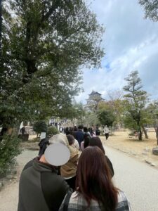 広島城の敷地内を歩く長蛇の列。列の先には天守閣が見える。休日の混雑状況を伝えている。